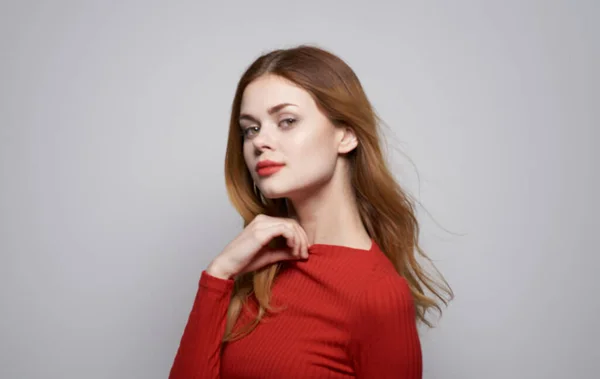 Retrato de una hermosa mujer con una camisa roja sobre un fondo gris haciendo gestos con las manos Copiar espacio —  Fotos de Stock