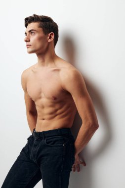 Çıplak gövdeli pantolonlu bir adam duvara yaslandı.