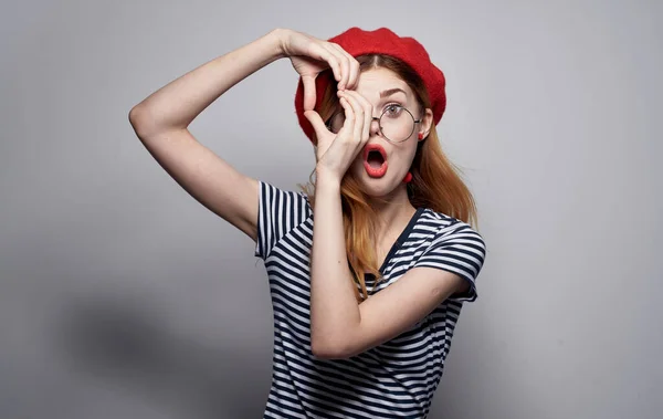 Una donna emotiva con gli occhiali e una maglietta a righe con le mani — Foto Stock