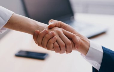 İş adamları iş yerinde el sıkışıyor. Ofiste çalışanlar karşılıklı anlayış gösteriyor.