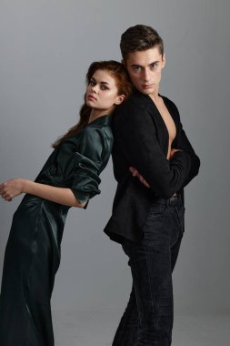 Kadın ve erkek arka planda yakın plan gri bir portreye dokunur.