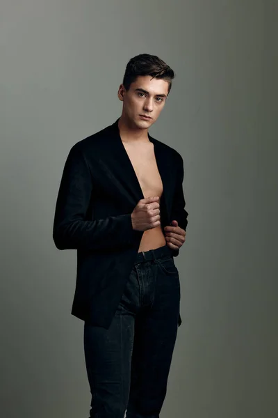 A man in an unbuttoned black jacket fashionable hairstyle — Stock Photo, Image