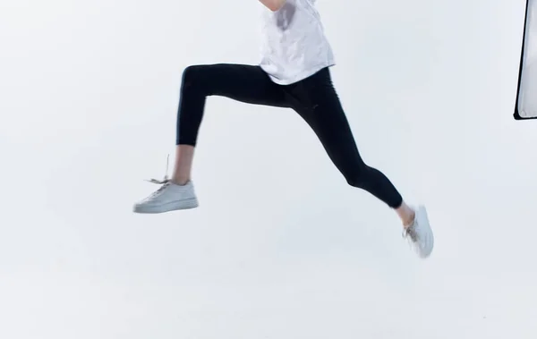 Γυναίκα στο αθλητικό ντύσιμο σε ένα ελαφρύ φόντο τρέχει fitness success energy — Φωτογραφία Αρχείου