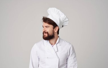 Mutfak gurmesi gri arka planda sakallı, profesyonel şef işi.