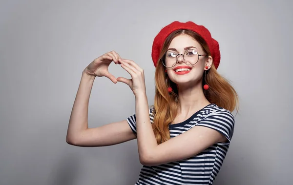 Une femme émotionnelle avec des lunettes et un t-shirt rayé gestes avec ses mains — Photo