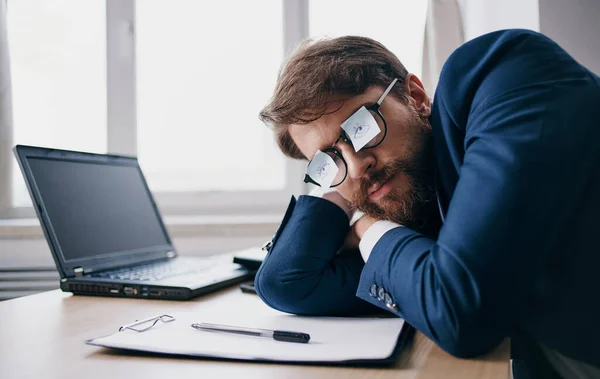 Homem de negócios dormindo no trabalho usando óculos com folhas de papel — Fotografia de Stock