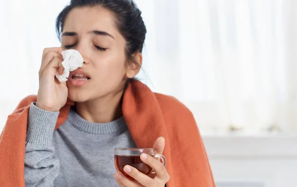 Mujer con una taza de servilleta de té en la mano problemas de salud secreción nasal vitaminas — Foto de Stock