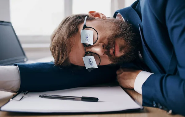 Homem de negócios em um terno adormeceu no trabalho na mesa no escritório — Fotografia de Stock