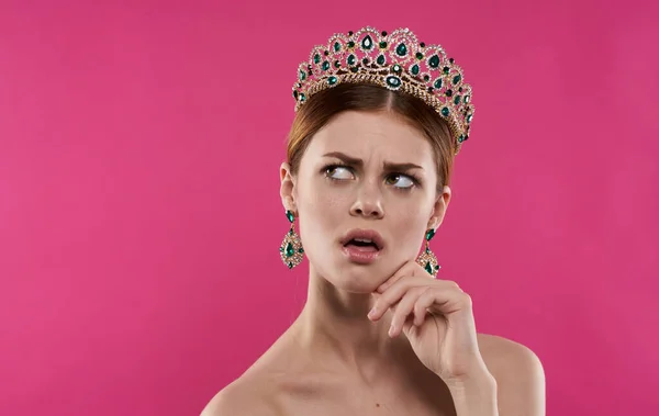 Donna emotiva con una corona sulla testa su uno sfondo rosa modello principessa — Foto Stock