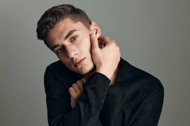 Yakışıklı, şık, siyah tişörtlü, kendine güvenen bir adam.