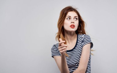 Neşeli, güzel, çizgili tişörtlü, kırmızı dudaklı bir kadın.