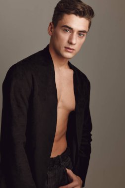 Yakışıklı, genç, şık, siyah gömlekli çekici bir poz.