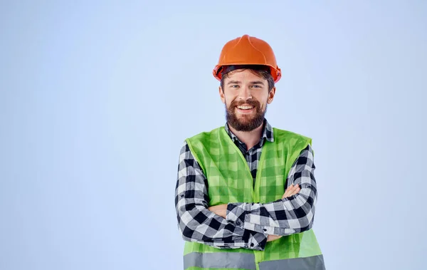 青の背景にオレンジのハード帽子の建設労働者とシャツの反射ベストを果たした — ストック写真