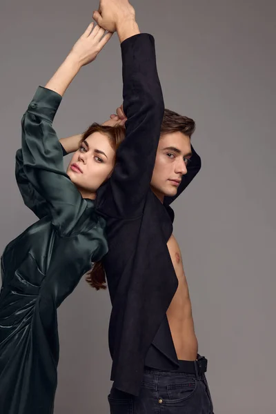 Um homem sexy em uma camisa desabotoada e uma mulher em um vestido com as mãos levantadas — Fotografia de Stock