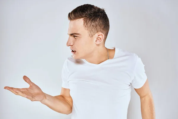 Hombre en camiseta blanca disgustado expresión facial gesto con las manos estilo de vida estudio —  Fotos de Stock