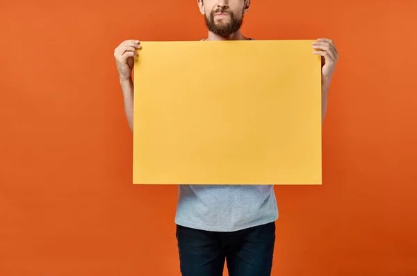 배경 화면에는 주황색 배경 사진 작가의 마케팅 포스터가 찍혀 있다 — 스톡 사진
