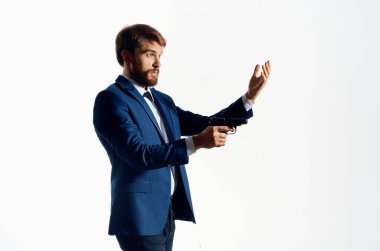 Elinde silah olan takım elbiseli bir adam dedektiflik suçlarına dikkat ediyor.
