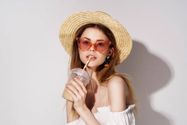 Belle femme en verre de chapeau de lunettes roses avec un fond clair de charme boisson — Photo