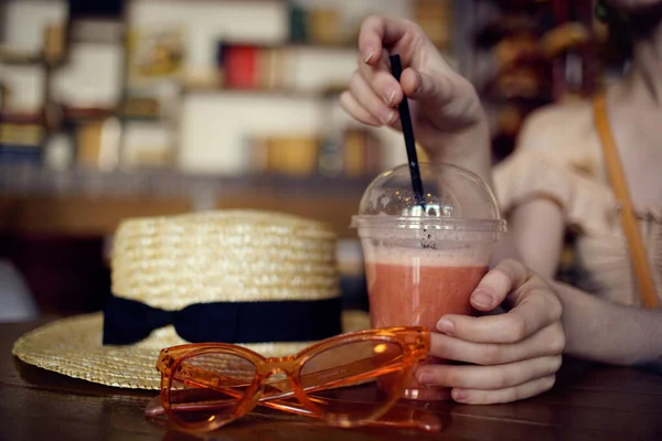 Een vrouw zit in een restaurant met een koptelefoon een glas verse glazen vrije tijd — Stockfoto