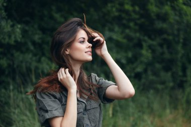 Ormandaki kadın yeşil takım elbiseli elleri yüzün yanında yaz tatili 