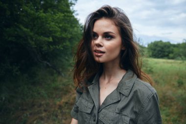 Çayırda bir kadın kırpılmış manzaraya bakıyor. Temiz hava. 