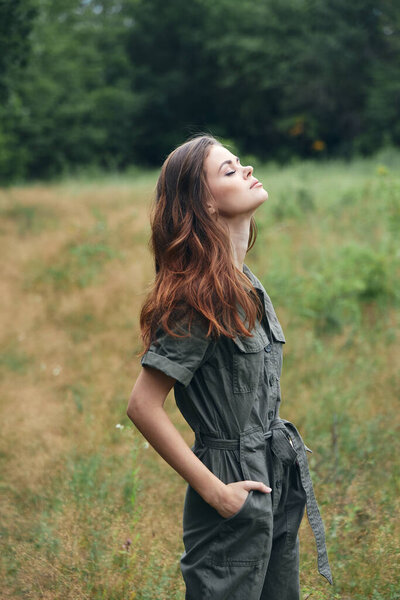 Woman in the forest summer landscape gray jumpsuit close-up side view