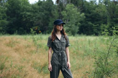 Dışarıda, ormanda, tulumlu bir kadın.