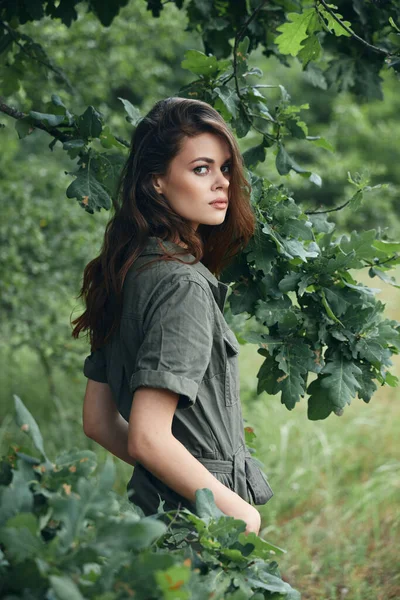 Woman in the forest Green jumpsuit attractive look green leaves