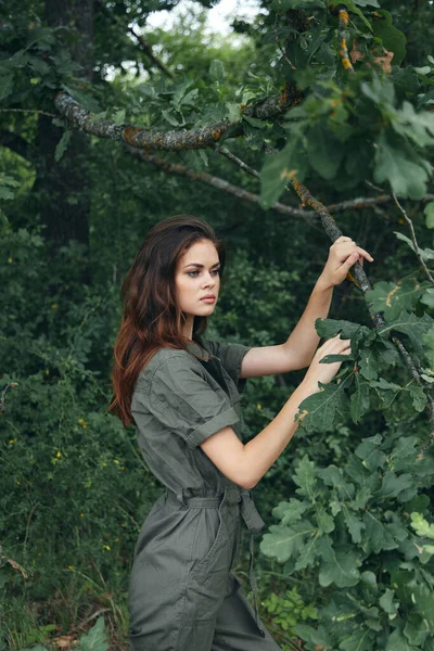 Retrato de uma mulher Segurando as mãos em um galho de árvore folhas verdes viajam — Fotografia de Stock