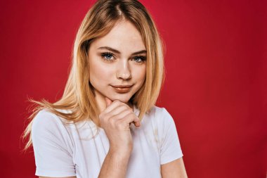 Güzel kadın gülümsüyor beyaz tişört kesilmiş dallar kırmızı arka plan