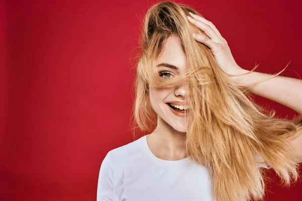 Güzel kadın gülümsüyor beyaz tişört kesilmiş dallar kırmızı arka plan — Stok fotoğraf