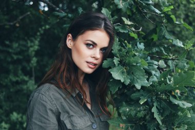 Ormandaki kadın, ağaçların ilerisine bak, çalılığın yeşil yaprakları.