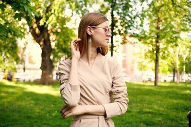 Parkta güneş gözlüklü neşeli bir kadın.