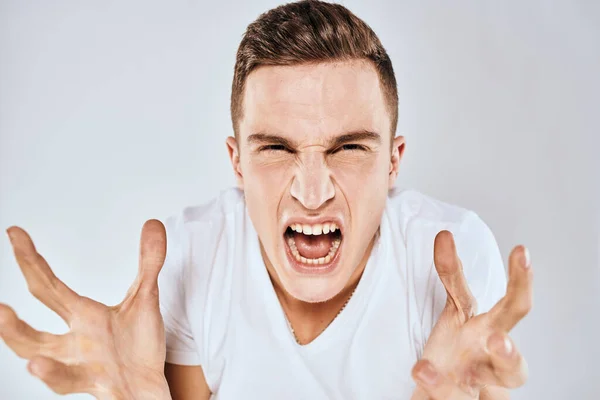 Emotionell man gest med händerna missnöjd ansiktsuttryck vit t-shirt beskärs — Stockfoto