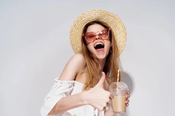 Jolie femme joyeuse dans des lunettes roses chapeau d'émotions dans un verre avec une boisson de luxe — Photo