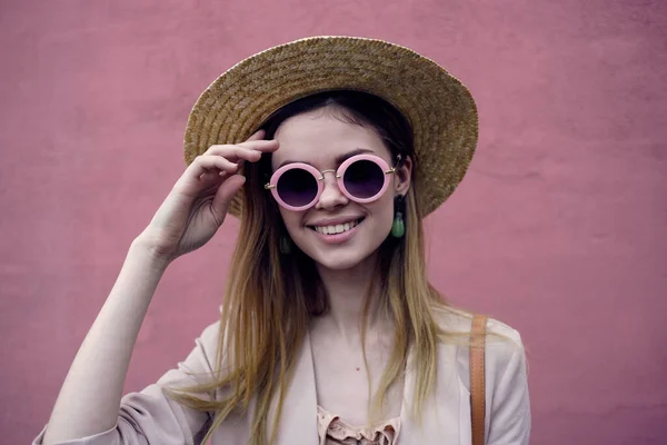 Vacker kvinna i solglasögon och hatt leende attraktiv look rosa bakgrund — Stockfoto