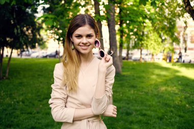 Yeşil ağaçların arasında güzel bir kadın dinleniyor.