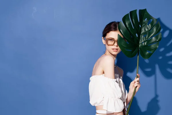 Kvinna bär solglasögon palm kosmetika sommar resa blå bakgrund — Stockfoto