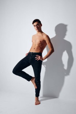 Pantolon giyen bir sporcu, tek bacağının üzerinde duruyor.