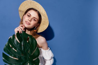 Şapkalı kadın ellerinde lüks egzotik mavi arka plan