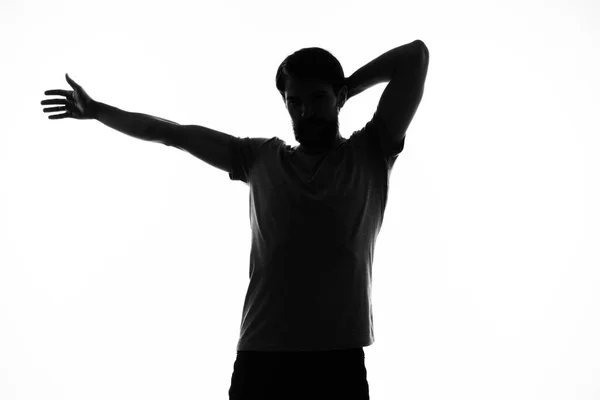 Silueta negra de un hombre que hace gestos con las manos sobre un fondo claro — Foto de Stock