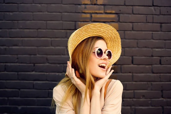 Женщина в солнечных очках и шляпа украшения прогулка на открытом воздухе кирпичная стена на заднем плане — стоковое фото