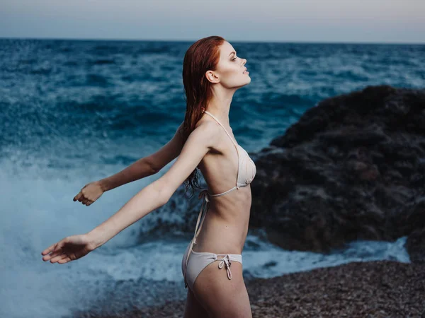 Donna sexy in costume da bagno sulla spiaggia vicino al mare in gesti natura con le mani — Foto Stock