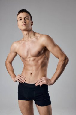 Siyah şortlu atletler ve kemer kesikli bir manzarada el ele tutuşan pompalı bir gövde.