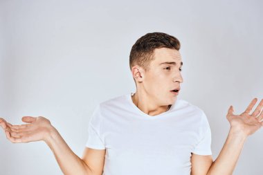 Beyaz tişörtlü hoş bir adam elleriyle jestler yapıyor. Duyguları stüdyoyu şaşırtıyor.