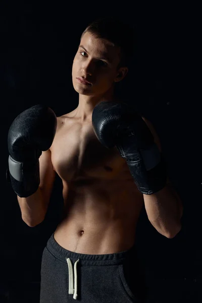 Sportovní chlap na černém pozadí v boxerských rukavicích nafouklý trup oříznutý pohled Model Kopírovat prostor — Stock fotografie