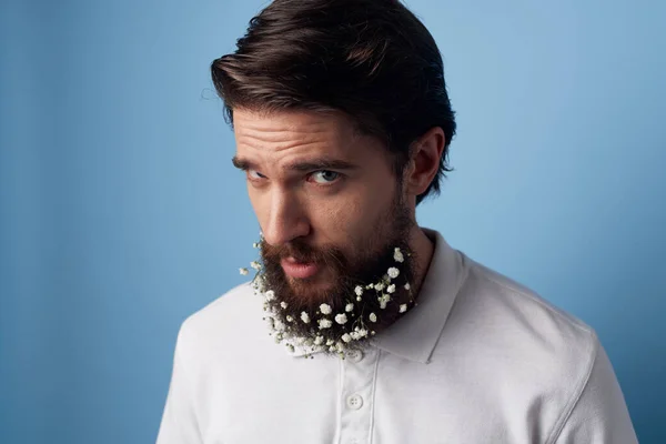 Beyaz gömlekli sakallı, çiçekli, mavi arka planlı bir adam. — Stok fotoğraf