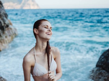 Deniz kenarındaki mutlu turist kadın doğayı sallıyor.