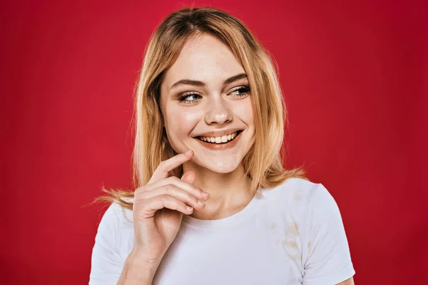 Mulher bonita sorriso branco t-shirt cortada ramos vermelho fundo — Fotografia de Stock