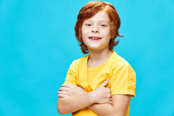 Glada rödhårig pojke korsade hans armar gul t-shirt beskärd utsikt — Stockfoto